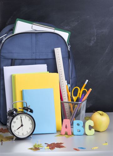 backpack with books, clock, ABC letters, cup with scissors and pencil, apple